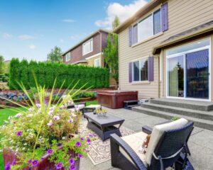 A backyard with patio furniture and a hot tub upgraded by Concrete Contractors.
