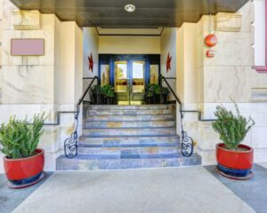 The entrance to a City building with red potted plants.